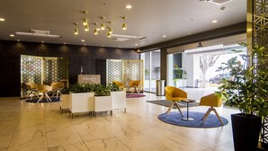 A modern reception area with a reception desk, seating arrangements, and a large window providing a view of the outside.
