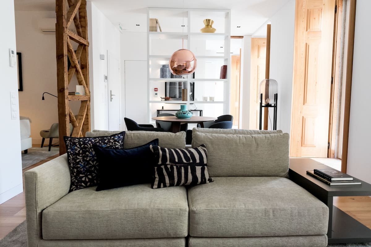 A modern living room with a sofa, a coffee table, and a bookshelf.
