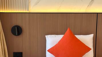 Una habitación de hotel con una cama, una mesita de noche, una lámpara de pared y una pared con diseño de mármol.