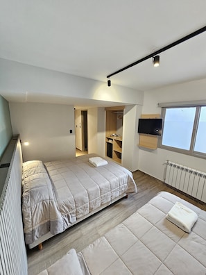 A modern bedroom with a bed, a sofa, a TV, and a window. - M383 Hotel Bariloche (San Carlos de Bariloche)