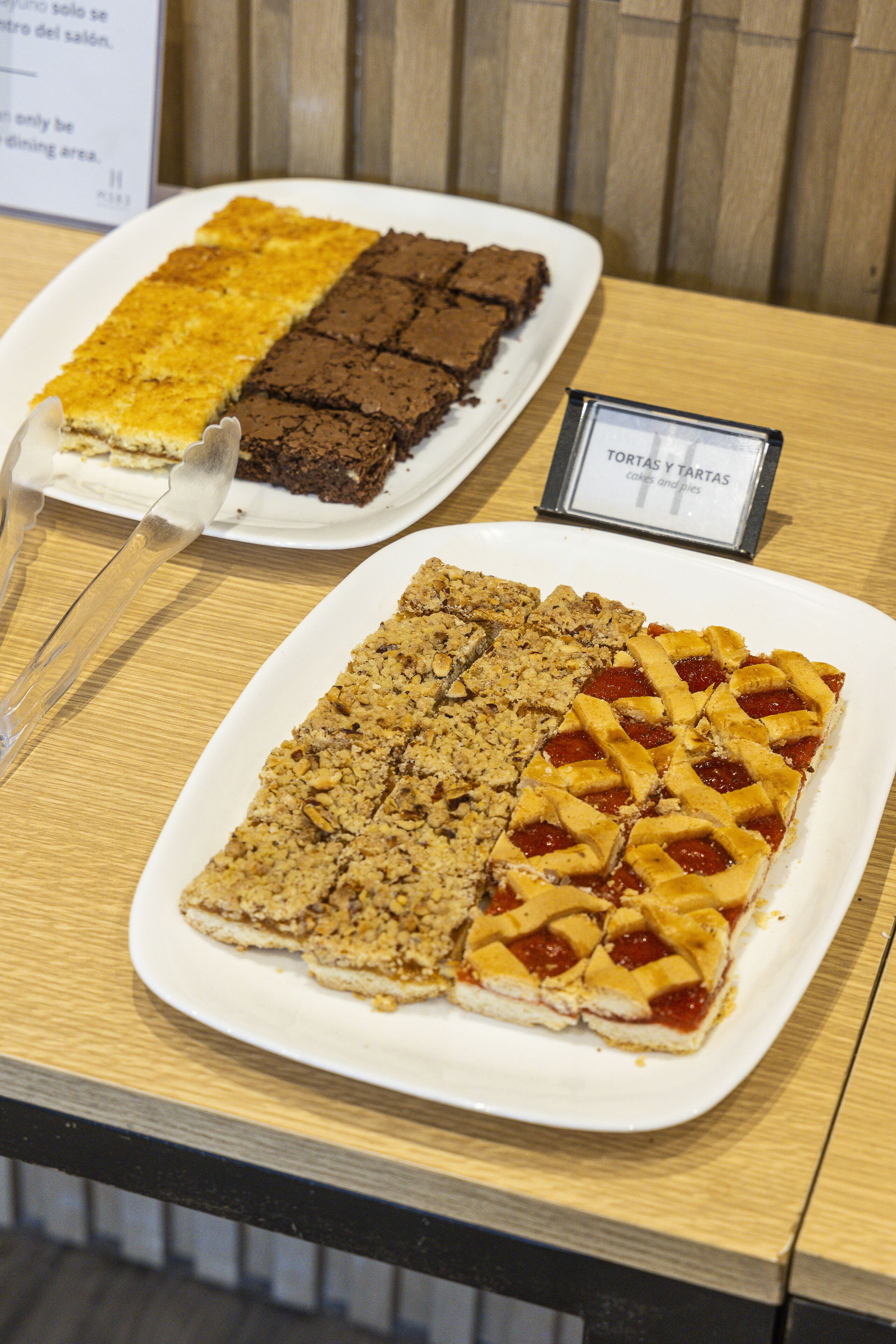 Un aparador de postres amb diferents pastissos i tartes sobre plats blancs.