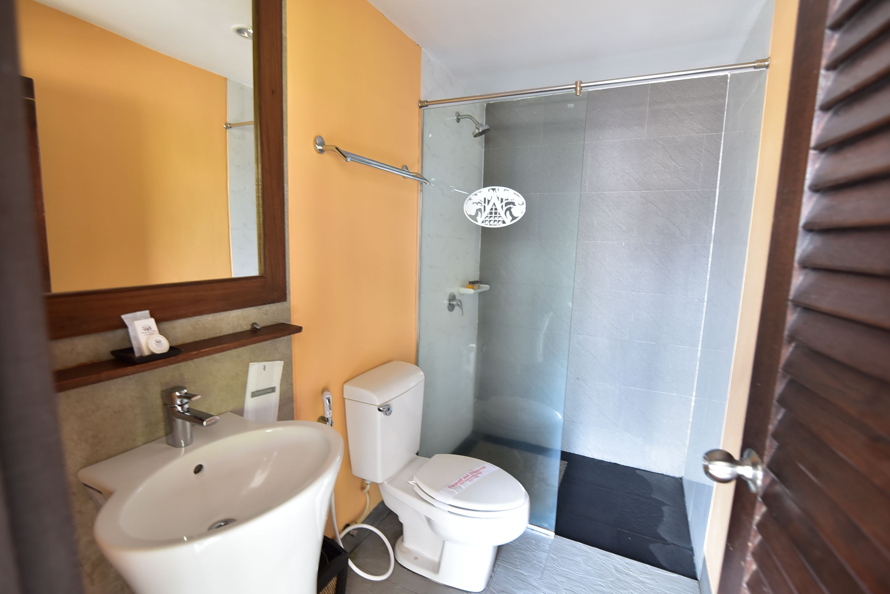 Un baño con lavamanos, inodoro y ducha blancos.