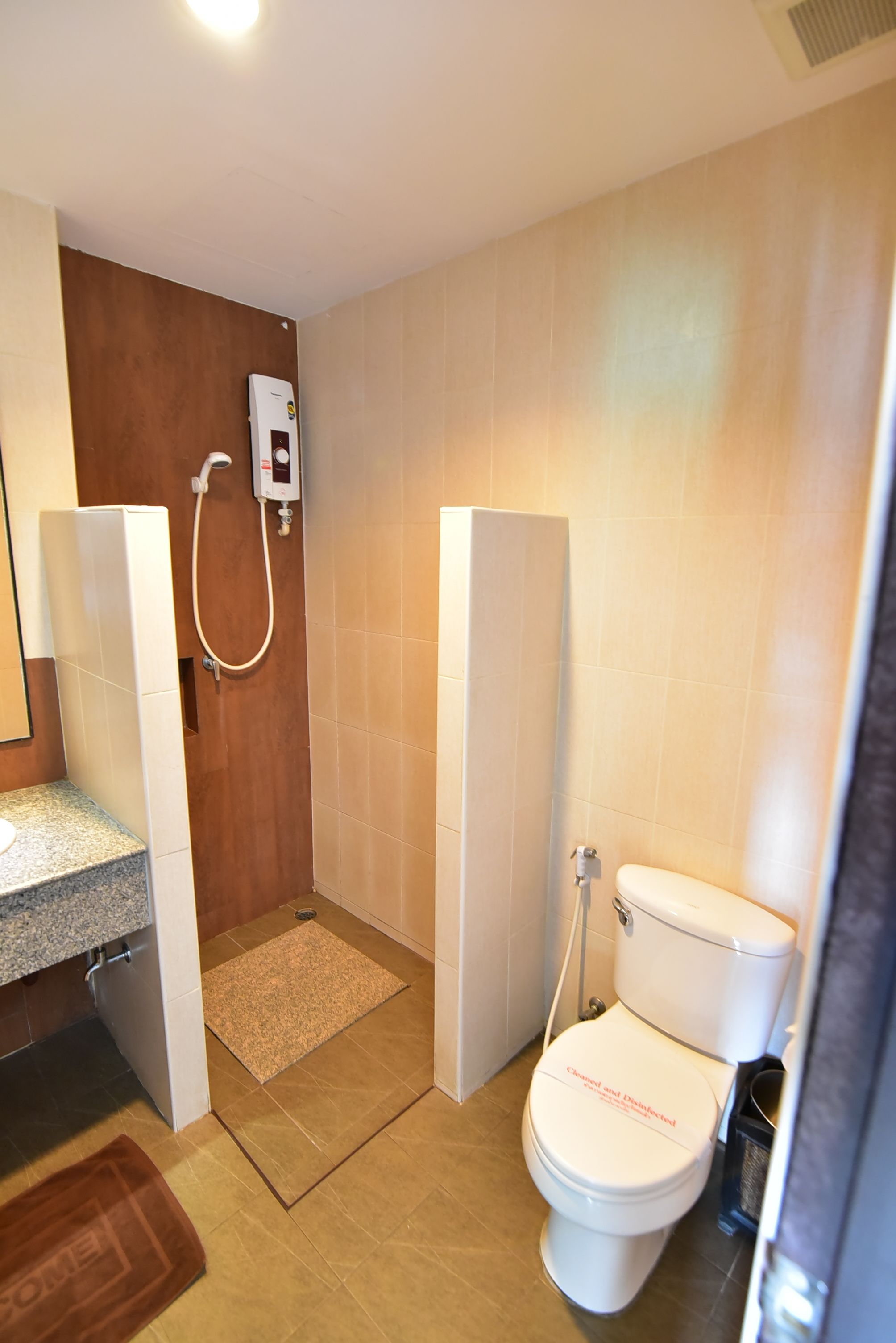 A modern bathroom with a shower, toilet, and sink.