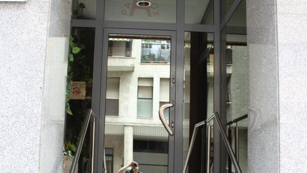 A building entrance with a glass door, a staircase, and a visible number '20' on the wall. - Hostal Palafox (Barbastro)