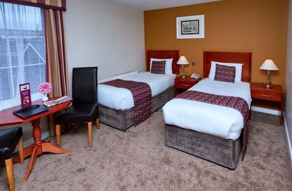 A hotel room with two beds, a desk, and a chair. - Eviston House Hotel (Killarney)
