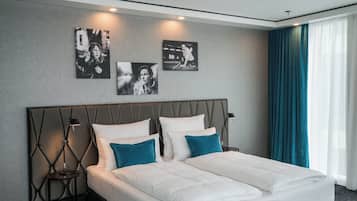 Una habitación de hotel moderna con una cama grande, dos mesitas de noche y una obra de arte colgada en la pared.