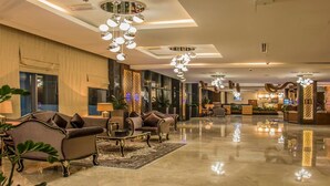 A spacious lobby with a polished floor, elegant seating, and decorative lighting fixtures. - Golden Tulip Headington Ruwi (Muscat)