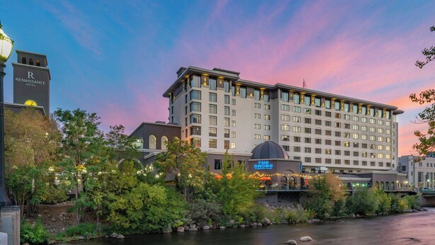 A hotel with a river in front, a clock tower, and a sign for 'The Shore'. - Renaissance Reno Downtown Hotel & Spa (Reno)