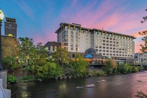 A hotel with a river in front, a clock tower, and a sign for 'The Shore'.