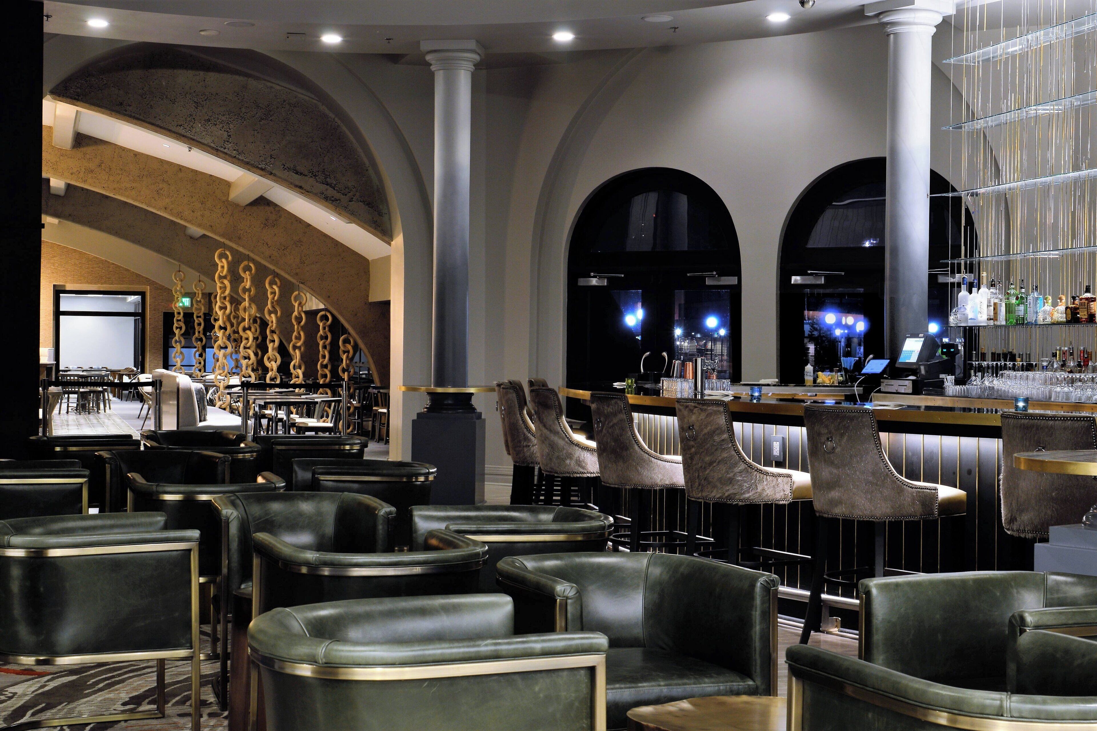 A bar area with leather chairs, a bar counter, and a seating area with tables and chairs.
