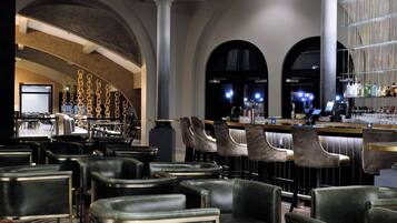 A bar area with leather chairs, a bar counter, and a seating area with tables and chairs.