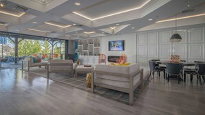 A spacious living area with a modern design, featuring a large sofa, dining table, and chairs. - Renaissance Reno Downtown Hotel & Spa (Reno)