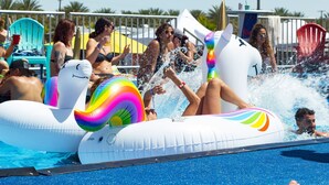 A pool area with inflatable water slides and lounge chairs.