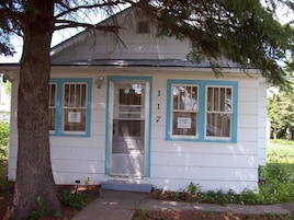A white house with blue trim and a number 17 sign.