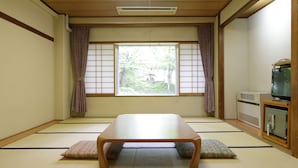 A traditional Japanese room with tatami flooring, a low table, and a television on a cabinet. - Yamanakako-Asahigaoka-Onsen Hotel Seikei (Yamanakako)