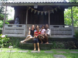 A wooden structure with a porch, decorative bunting, and a stone pathway. - D'tegale Homestay (Cepaka)