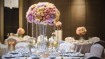 A banquet table set with fine china, glassware, and elegant floral centerpieces.