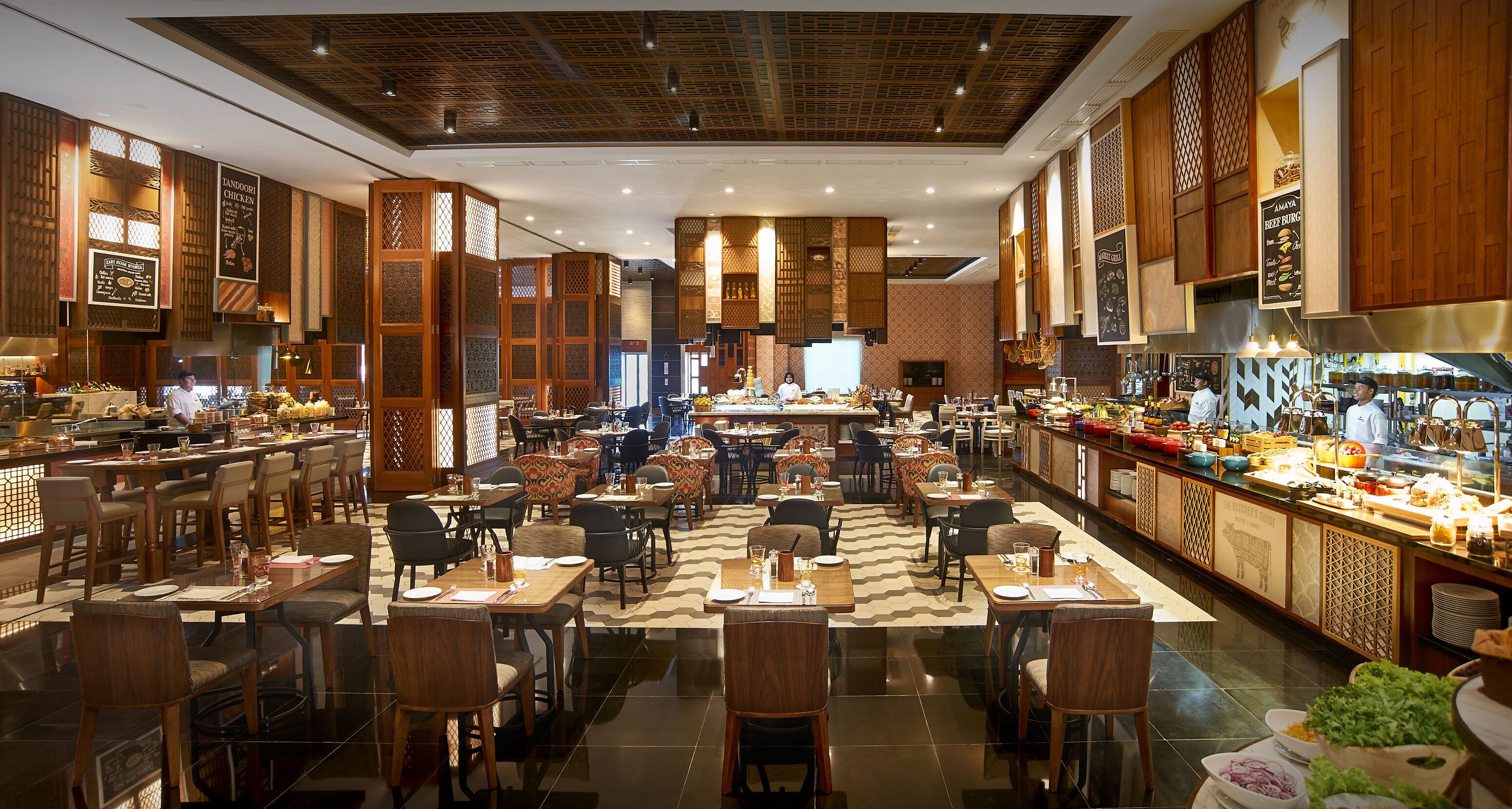 Un restaurante espacioso con techos altos, paneles de madera y diferentes opciones de asientos, incluyendo mesas y cabinas.