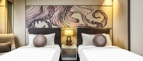 A hotel room with two beds, a nightstand with a lamp, and a decorative wall piece.