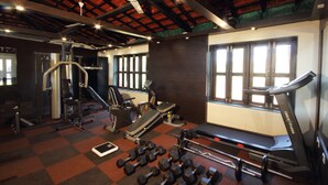 Une salle de sport équipée de tapis de course, d’haltères et d’appareils de musculation.