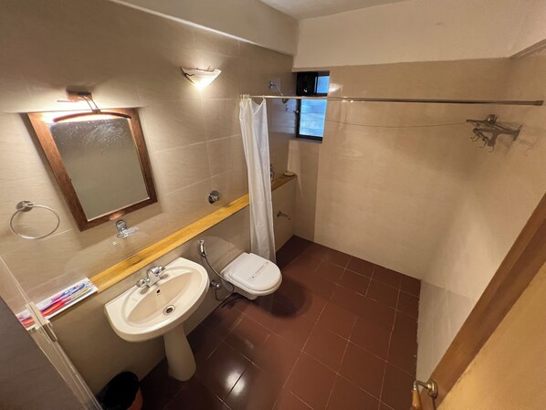 A bathroom with a sink, toilet, and shower area.