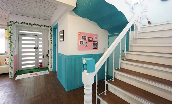 Una escalera con balaustres blancos y una pared de acento en color turquesa.