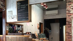 A reception desk with a wooden finish, a chalkboard with WiFi and contact information, and a sign welcoming guests to Star Inn. - Star Inn Tokyo - Hostel (Tokyo)
