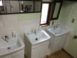 A bathroom with two sinks, a mirror, and a window. - Star Inn Tokyo - Hostel (Tokyo)