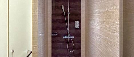 Een moderne badkamer met een douche, een wastafel en een spiegel.