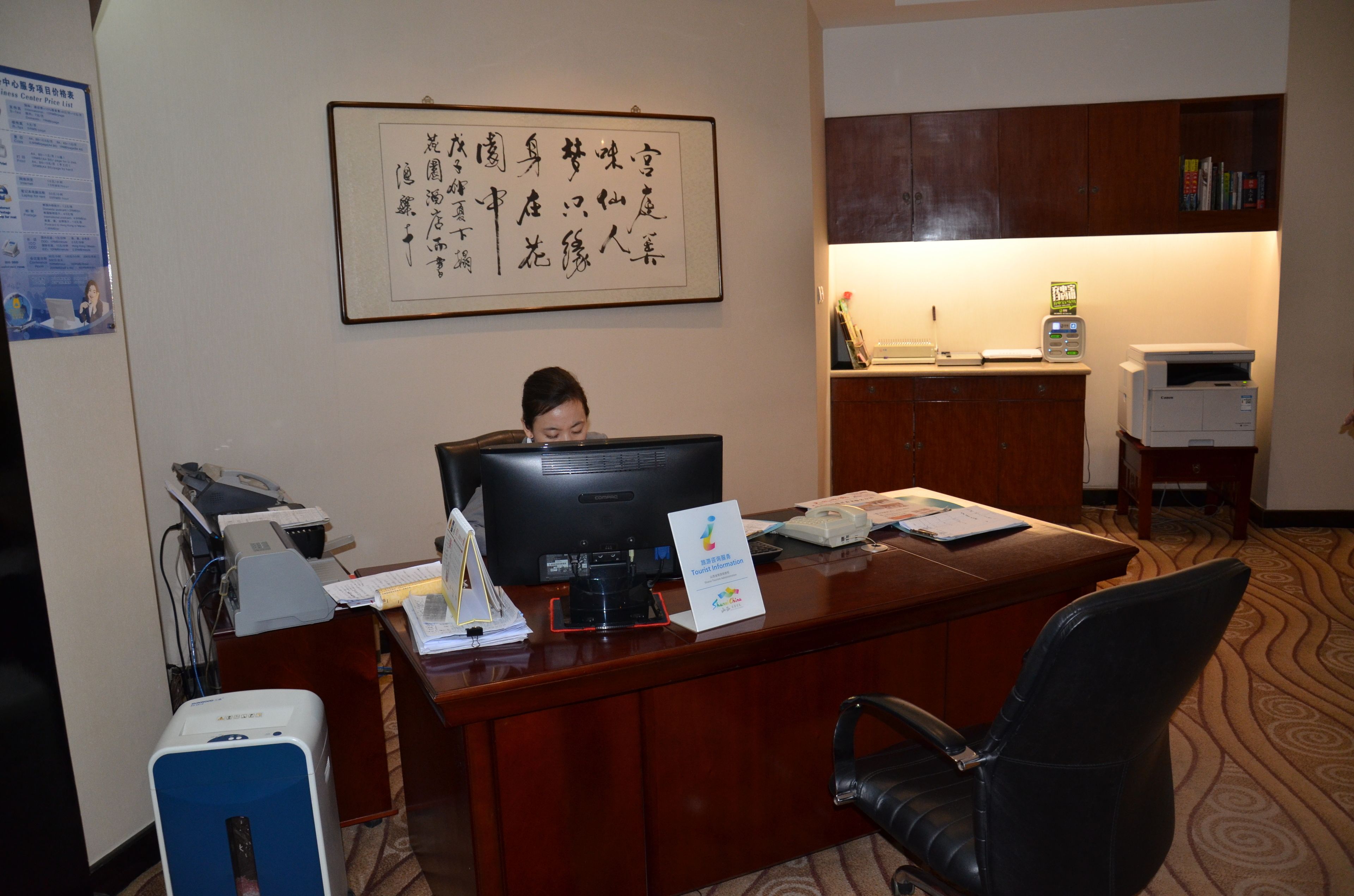 Una reception hotel con un computer, una stampante e diversi articoli di cancelleria.