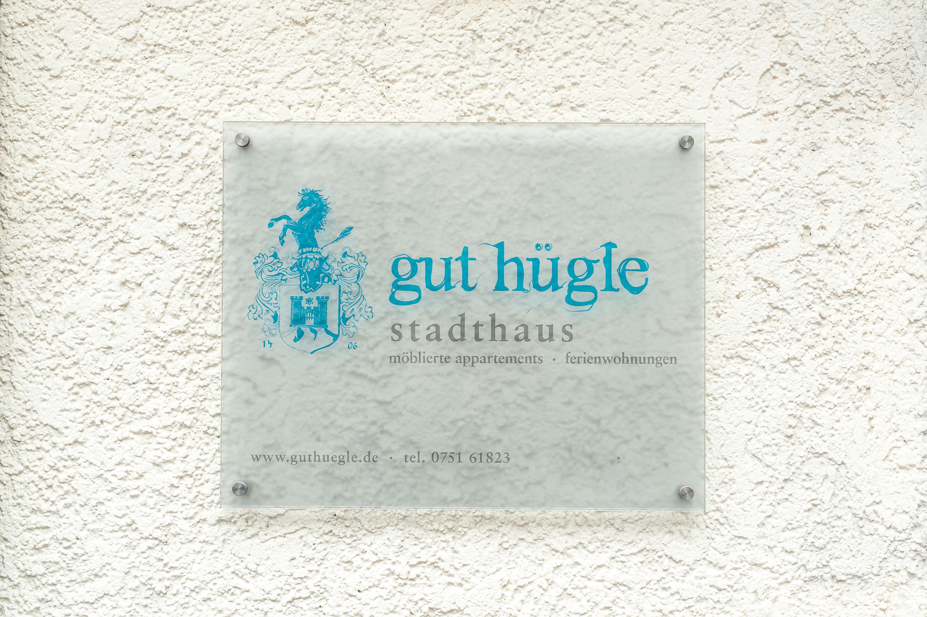 A sign with the text "gut hügle stadthaus" and a coat of arms.