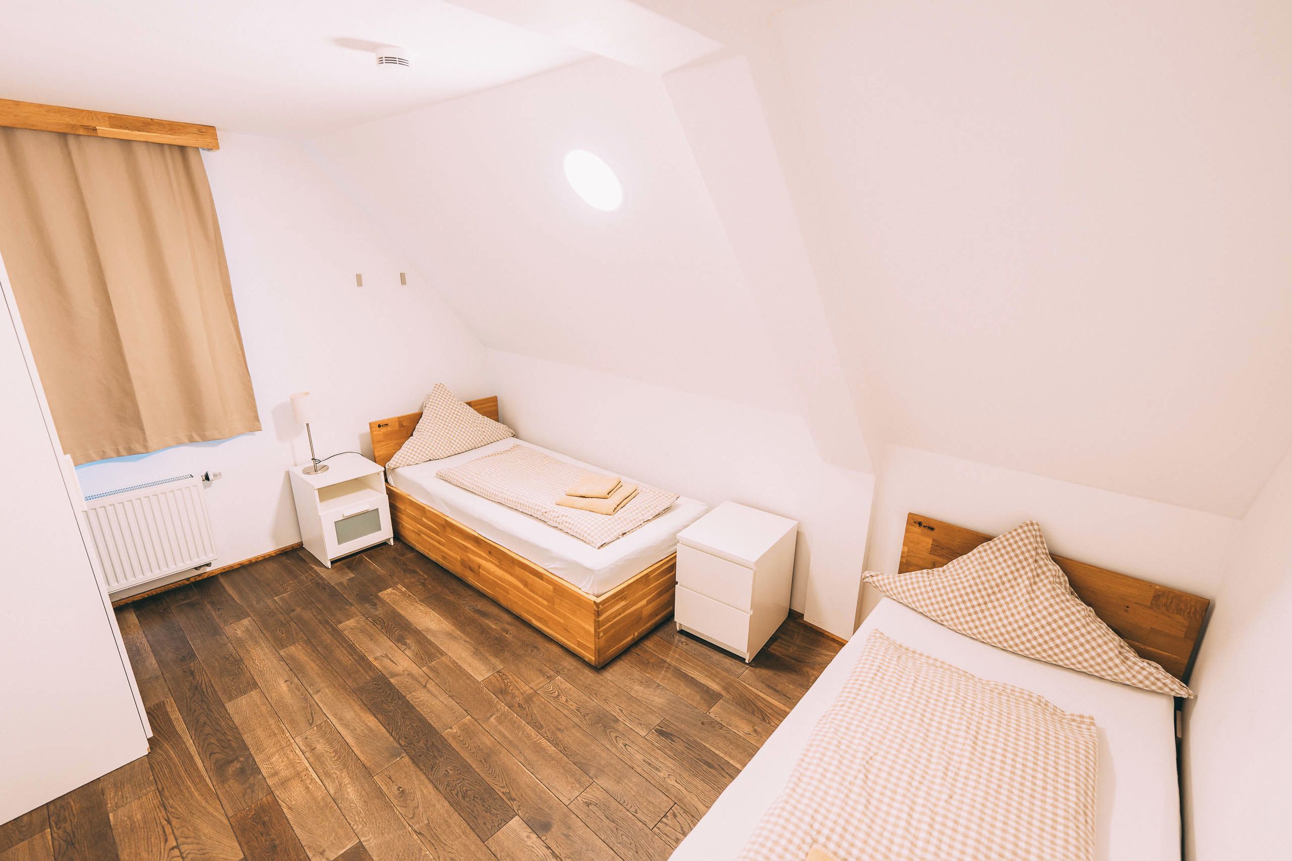 Un dormitorio con una cama de madera, una mesita de noche y un radiador.