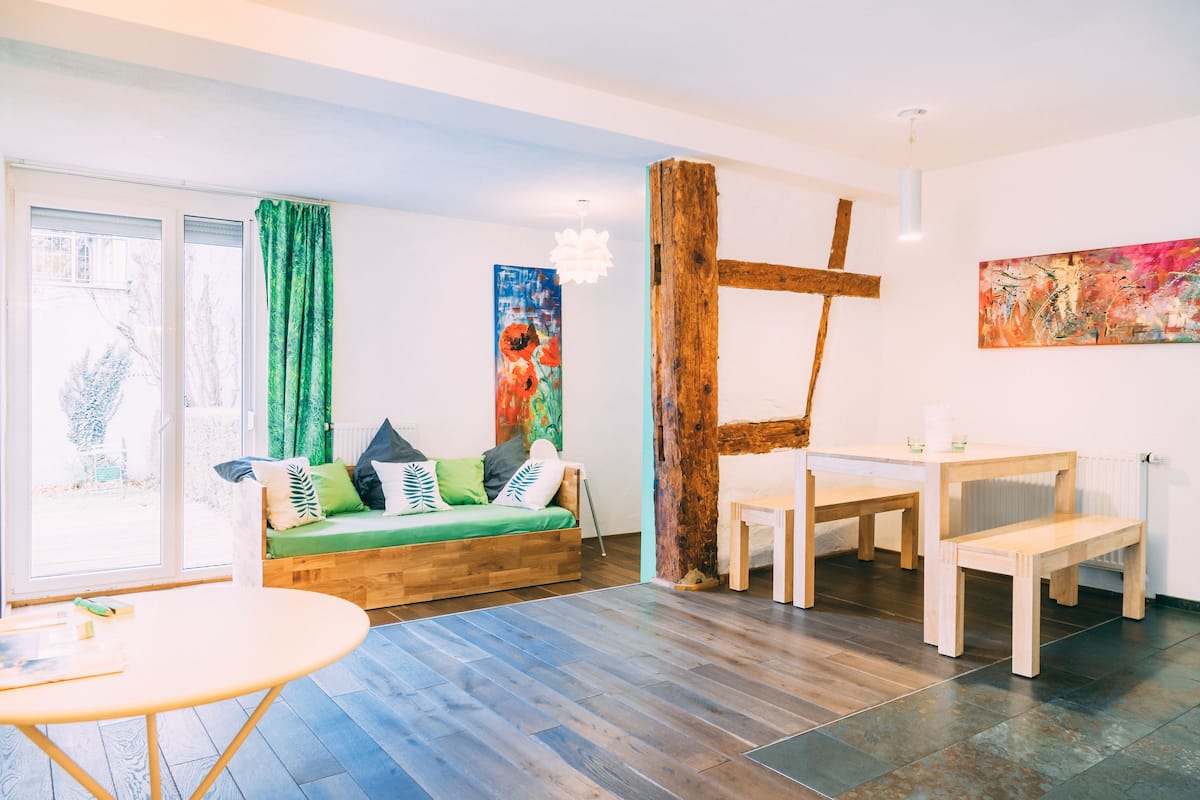 Ein modernes Wohnzimmer mit einem Holzsofa, einem runden Tisch und einer Bank.