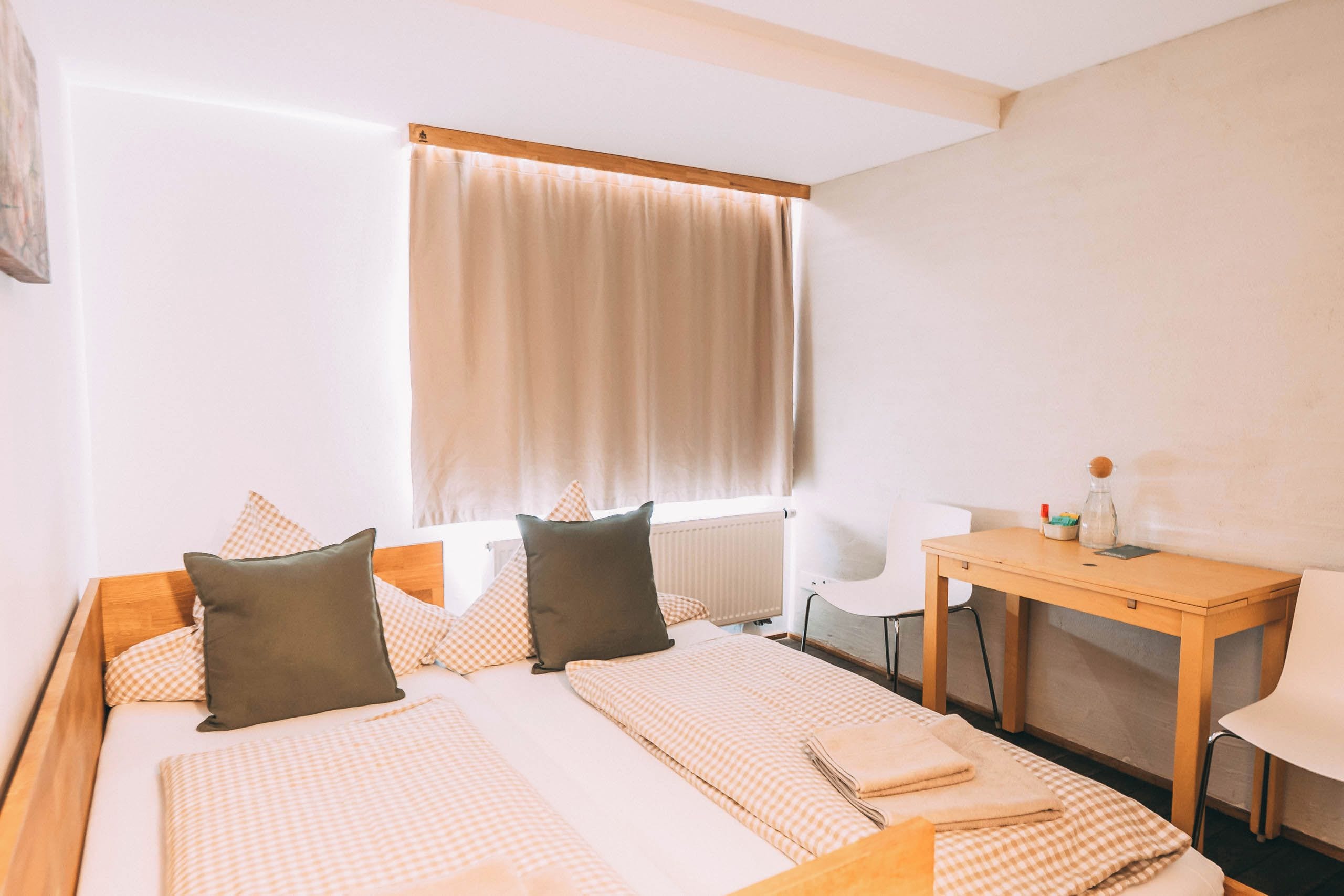Ein Hotelzimmer mit Bett, Schreibtisch und Stuhl.