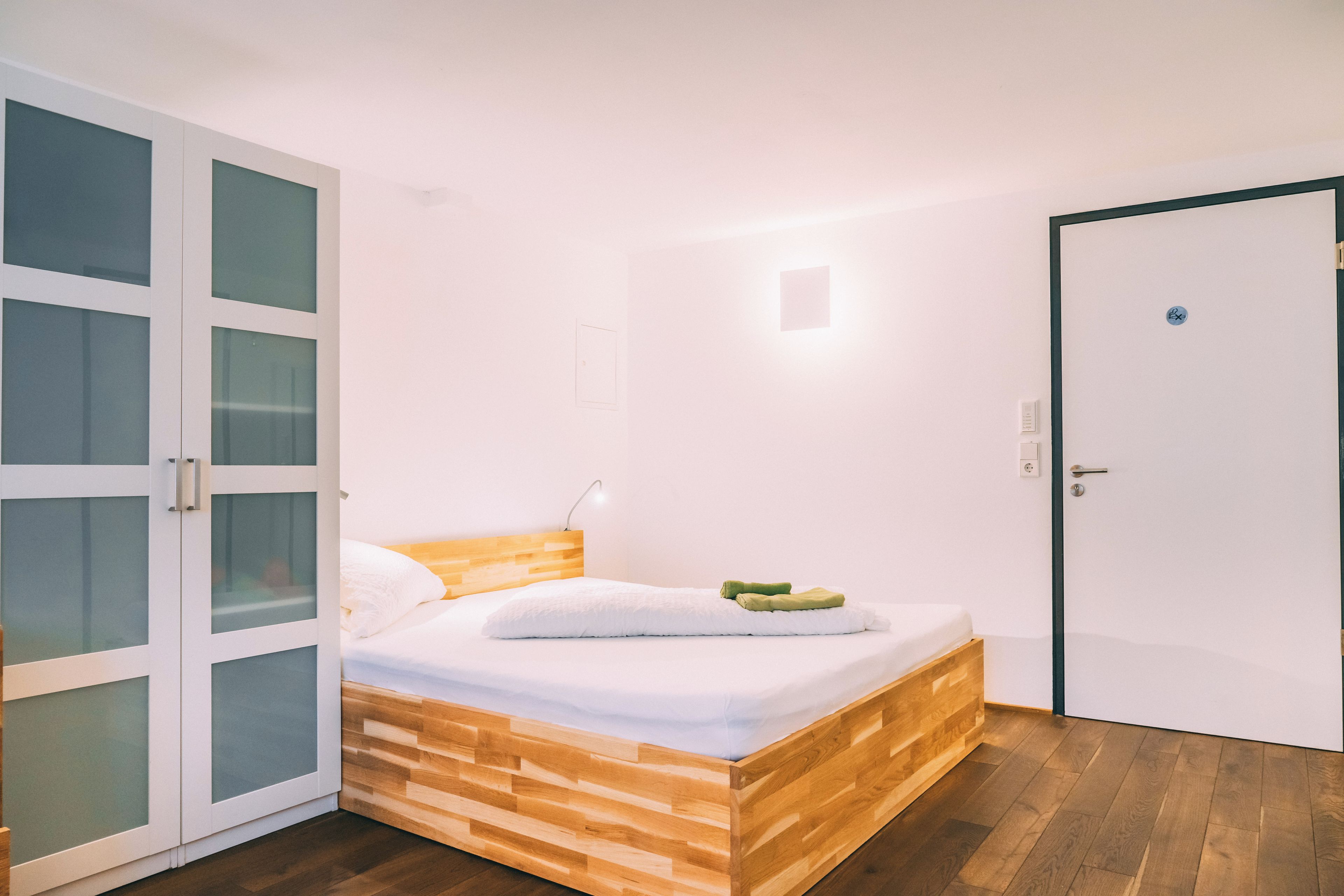 Een slaapkamer met een bed, een kledingkast en een deur.