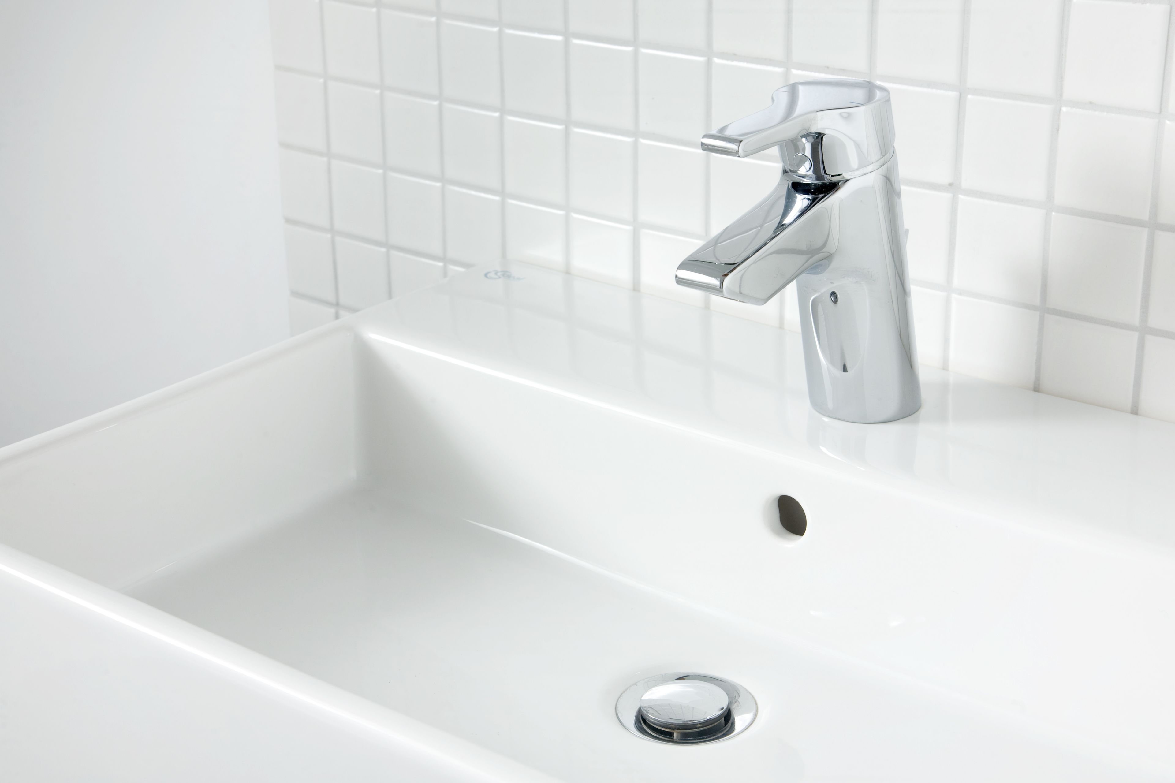 A white bathtub with a chrome faucet and a drain.
