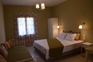 Una habitación de hotel con cama, escritorio, silla y armario.