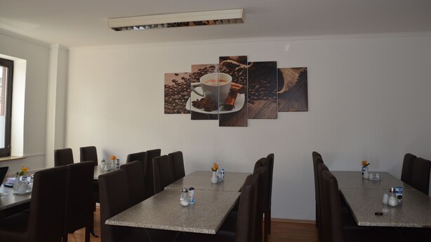 Une salle de conférence avec une longue table, de nombreuses chaises et une décoration murale sur le thème du café.