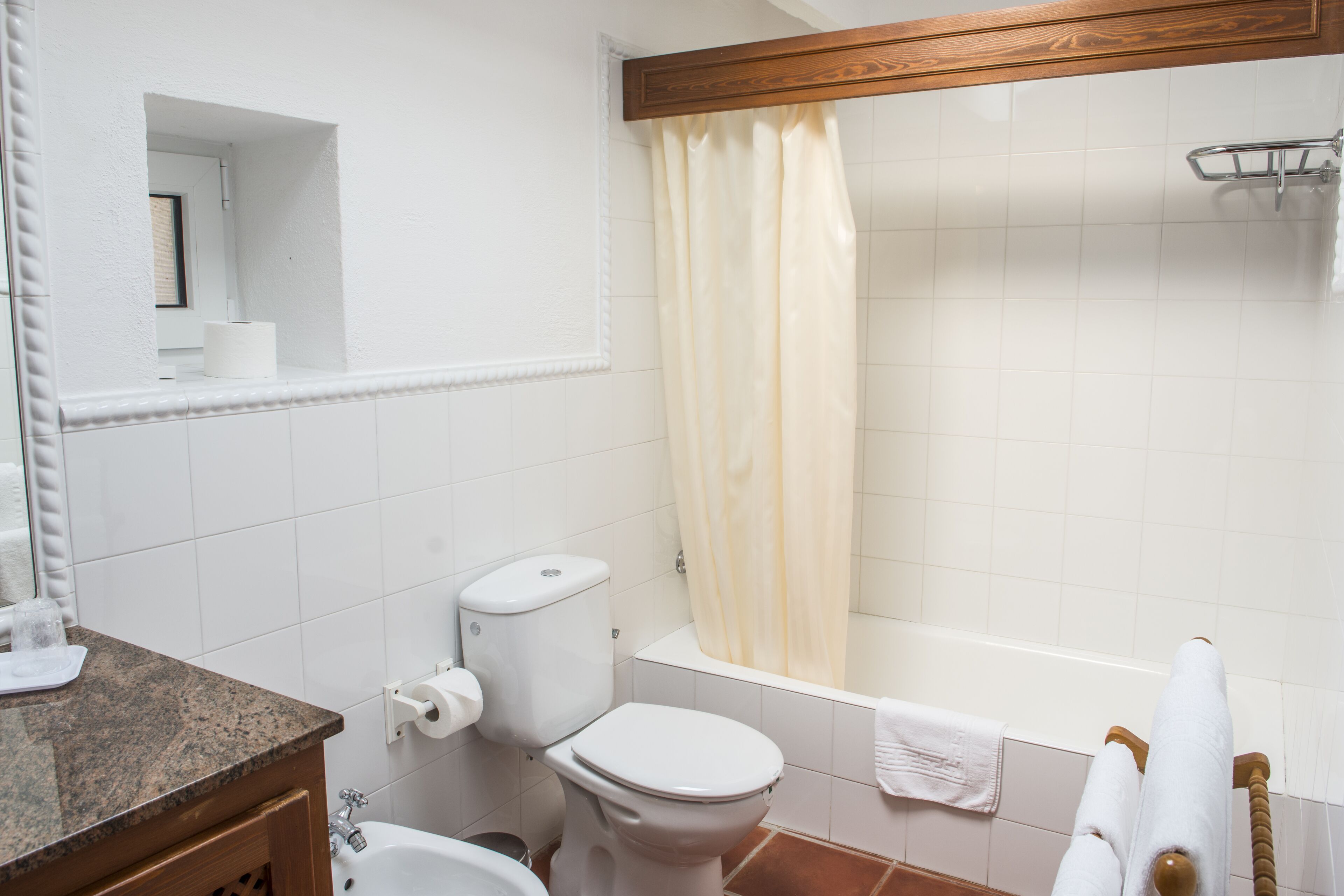 A bathroom with a toilet, sink, and bathtub.