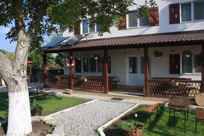 A building with a covered patio, outdoor seating, and a solar panel. - Bunica Maria (Mahmudia)