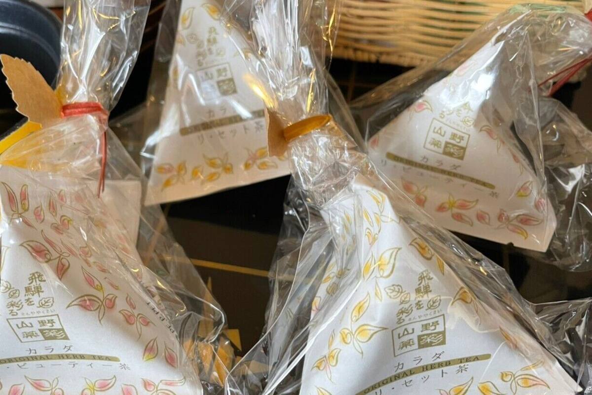 Varias bolsas de plástico con etiquetas de té, un tazón amarillo y una cesta de mimbre.