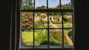 A view through a window with a brick wall and garden in the background. - Saltmarshe Hall (Goole)