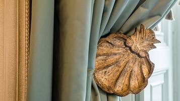 A close-up of a curtain with a wooden leaf-shaped decoration.
