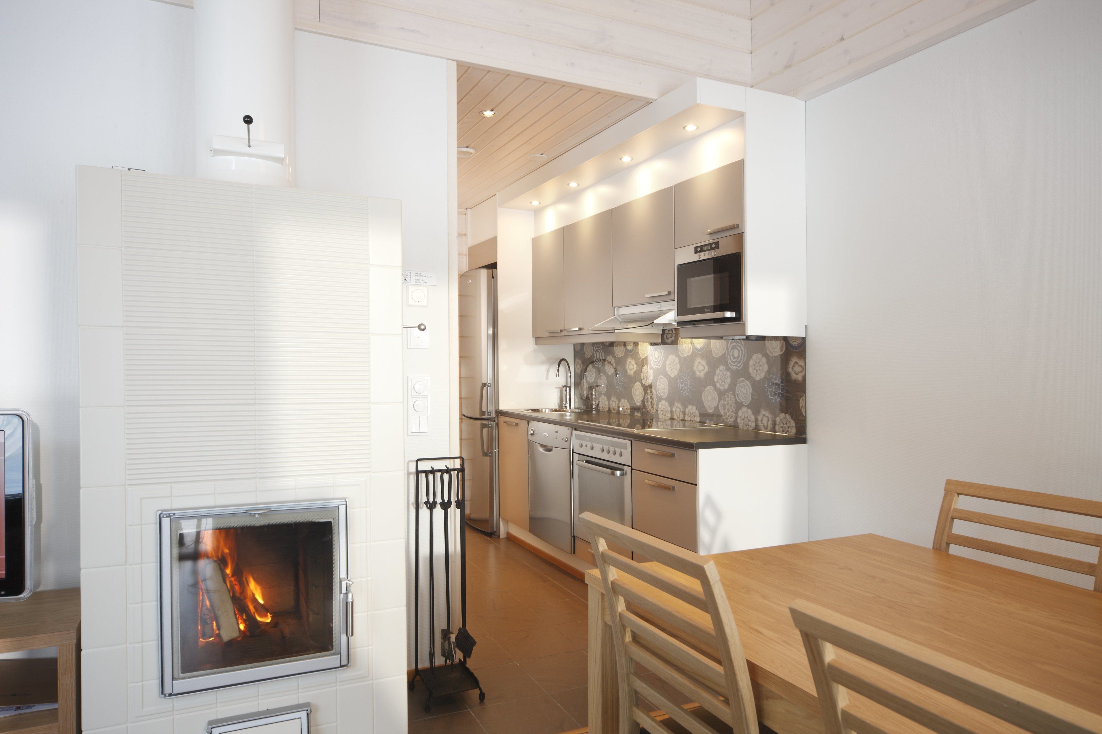 Eine moderne Küche mit Edelstahlgeräten, einer eingebauten Mikrowelle und einem Kamin.