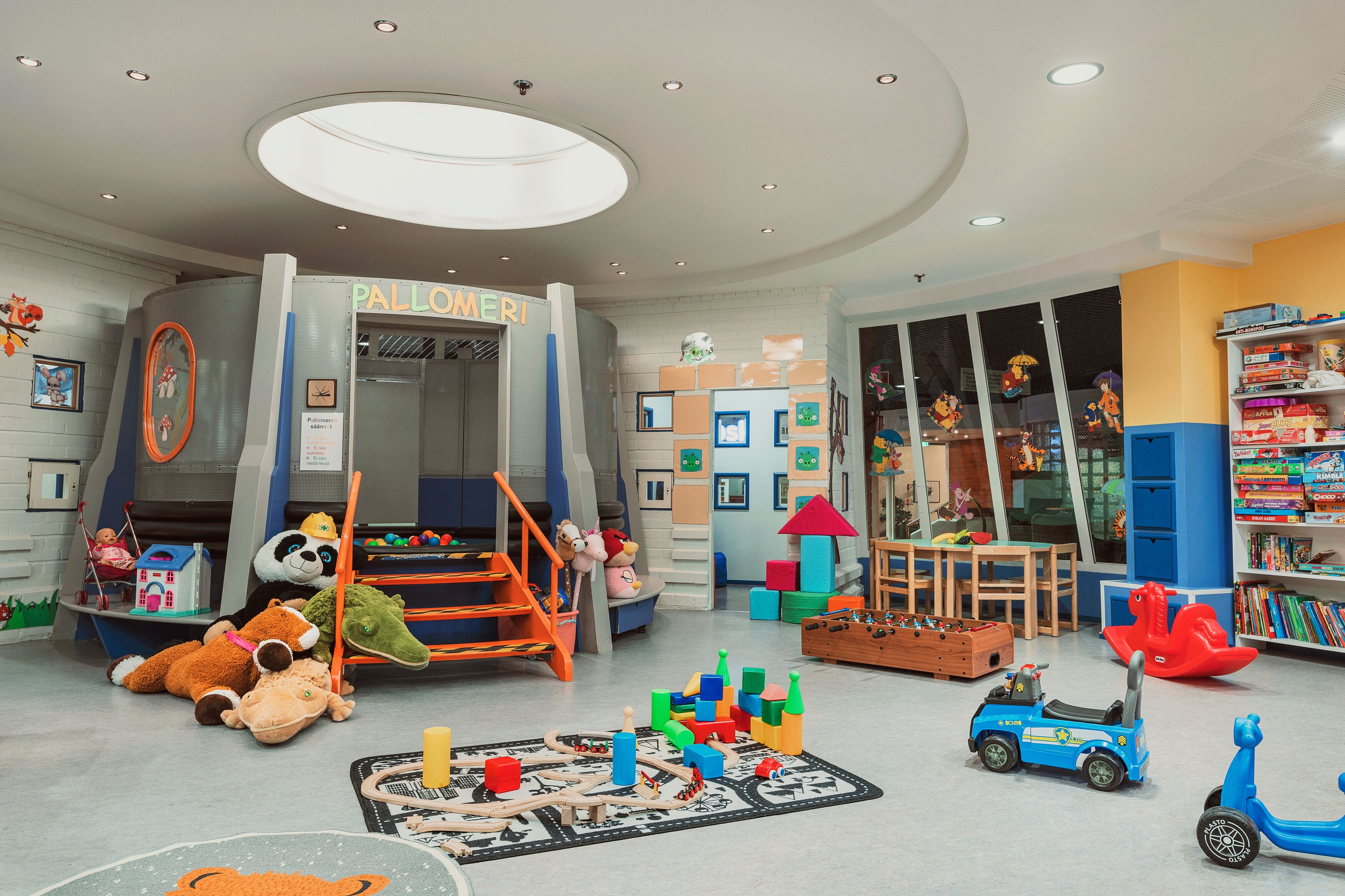 A children's play area with a slide, play structures, and a variety of toys and games.