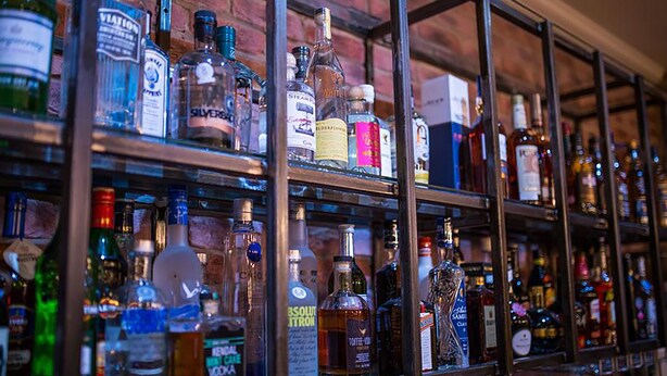 A bar with shelves of various liquor bottles. - The Crown Hotel (Morecambe)