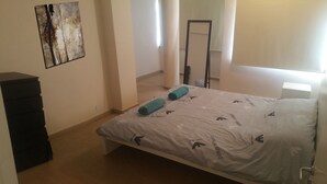 A bedroom with a bed, a black dresser, and a painting on the wall. - Ledras Town Center (Nicosia)