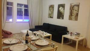 A dining area with a table set for two, a bottle of wine, and a sofa in the background. - Ledras Town Center (Nicosia)