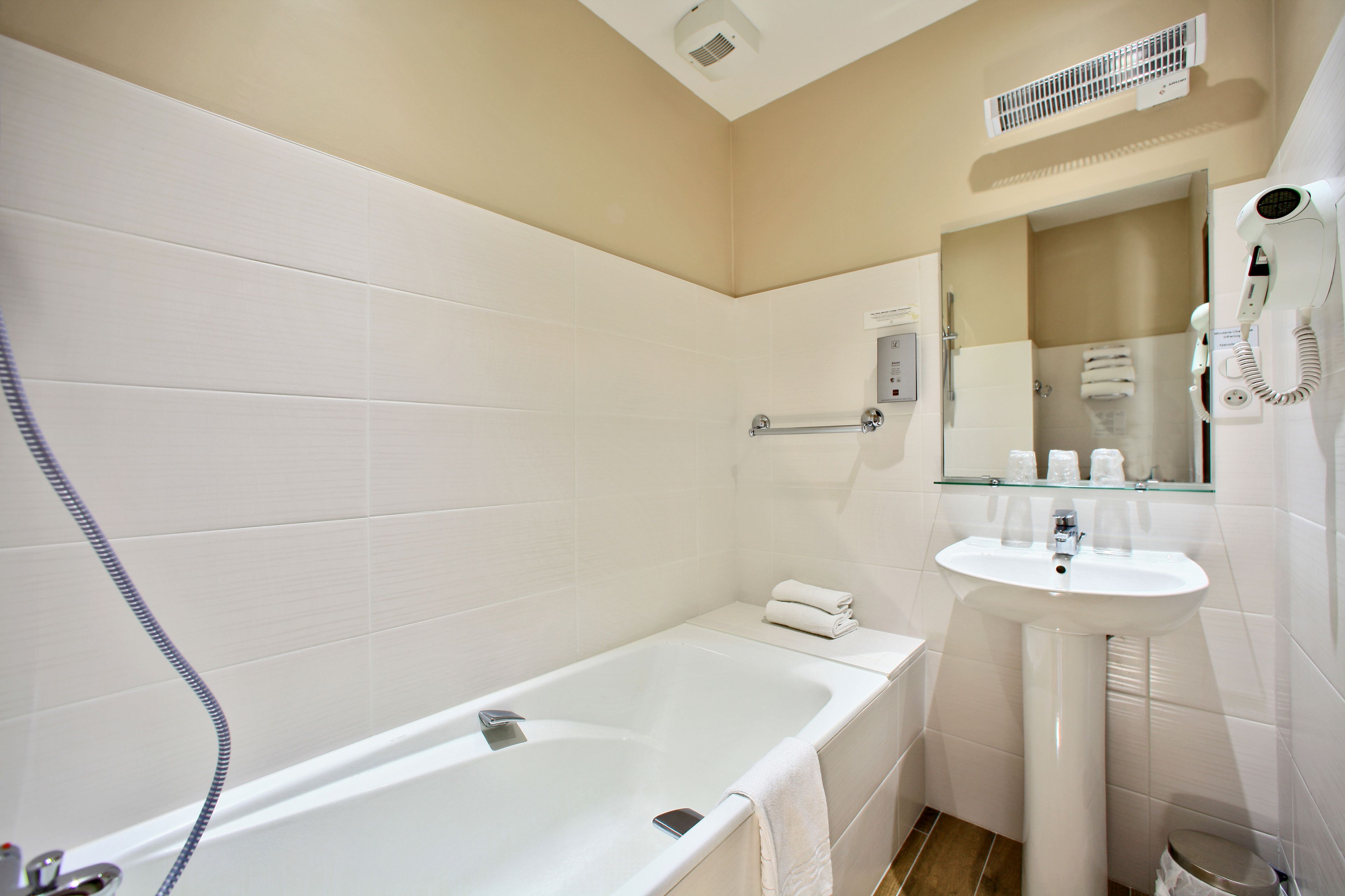 Un baño moderno con bañera, lavamanos y secador de pelo.