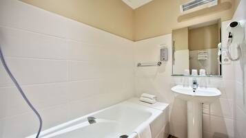 A modern bathroom with a bathtub, a sink, and a hairdryer.